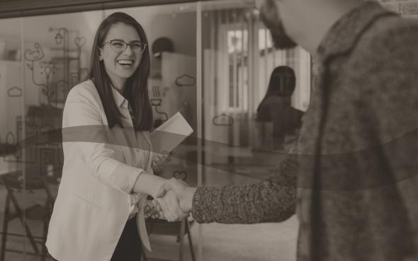 Lady smiling and shaking hands with man