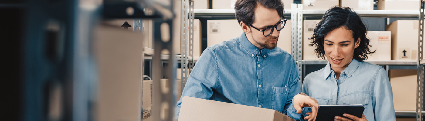 Landscape shot of two co-workers in package center