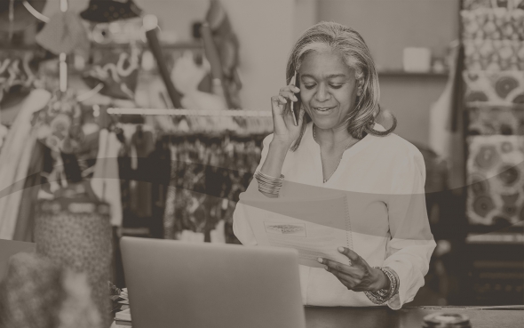 Woman on phone in front of laptop