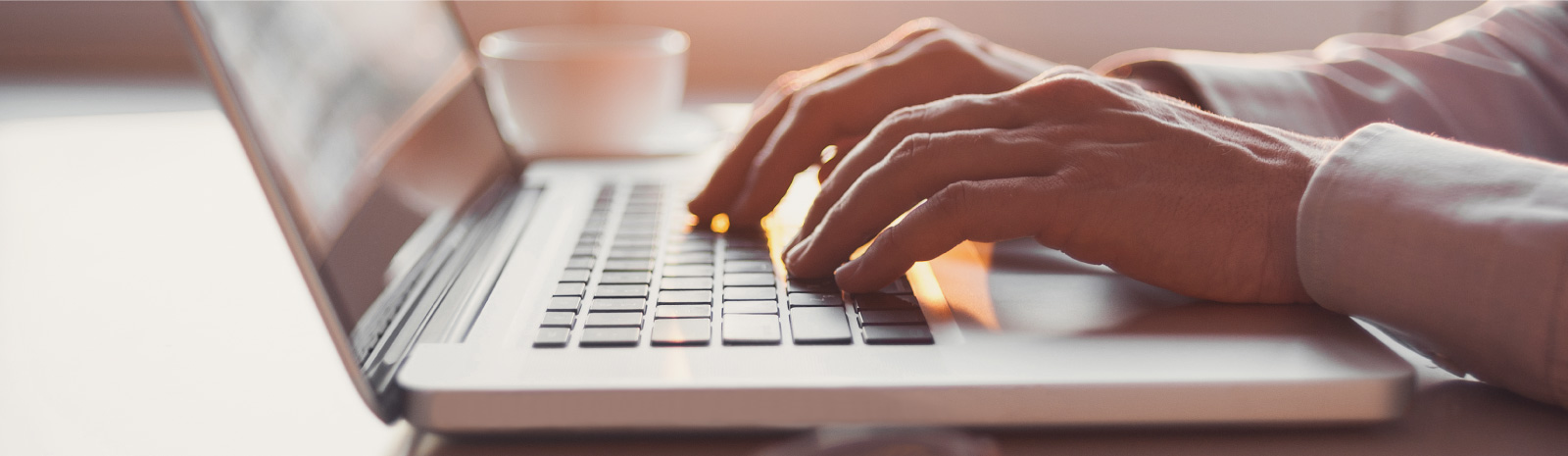 Hands typing on a laptop