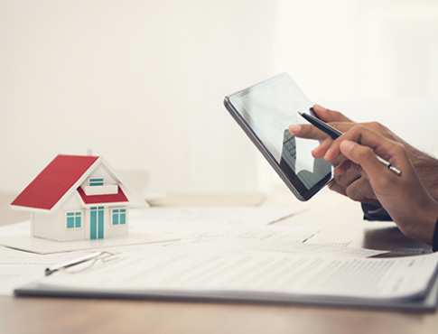 Person using tablet device at table with forms